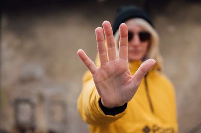 Young woman showing STOP sign with her palm