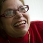 Judith Heumann smiling while wearing glasses