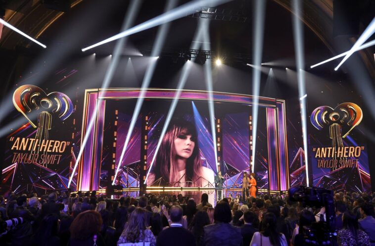 LOS ANGELES, CALIFORNIA - MARCH 27: (FOR EDITORIAL USE ONLY) (L-R) Taylor Swift accepts the Song of the Year award for