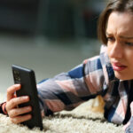 a worried teenager looking at her smartphone