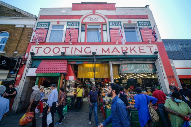 A picture of Tooting Market in the day time busy with vendors and visitors