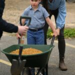 Britain's Prince Louis of Wales takes control of a wheelbarrow as he helps his mother, Britain's Catherine, Princess of Wales take part in the Big Help Out, during a visit to the 3rd Upton Scouts Hut in Slough, west of London on May 8, 2023, where they joined volunteers helping to renovate and improve the building. - People across Britain were on Monday asked to do their duty as the celebrations for King Charles III's coronation drew to a close with a massive volunteering drive. (Photo by Daniel LEAL / POOL / AFP) (Photo by DANIEL LEAL/POOL/AFP via Getty Images)