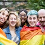 Group of young activist for lgbt rights with rainbow flag, diverse people of gay and lesbian community