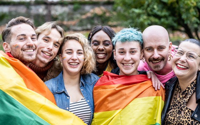 Group of young activist for lgbt rights with rainbow flag, diverse people of gay and lesbian community