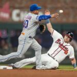 Jun 6, 2023; Cumberland, Georgia, USA; New York Mets third baseman Eduardo Escobar (10) throws for a double play over Atlanta Braves third baseman Austin Riley (27) during the first inning at Truist Park.