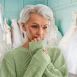 Woman looking sad in front of wedding gowns