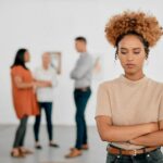 A woman being ostracised from her colleagues