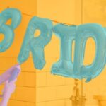 Girl inflating metallic balloon decorations that spell out the word 'Bride' for a Hen Party