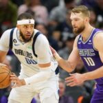 Feb 11, 2023; Sacramento, California, USA; Dallas Mavericks center JaVale McGee (00) handles the ball against Sacramento Kings forward Domantas Sabonis (10) during the third quarter at Golden 1 Center.