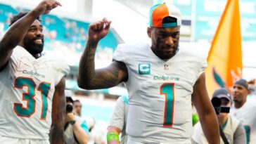 MIAMI GARDENS, FLORIDA - OCTOBER 15: Raheem Mostert #31 and Tua Tagovailoa #1 of the Miami Dolphins walk off the field after a win over the Carolina Panthers at Hard Rock Stadium on October 15, 2023 in Miami Gardens, Florida. (Photo by Rich Storry/Getty Images)