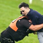 Ben Newman is tackled by police and security on the track at Epsom