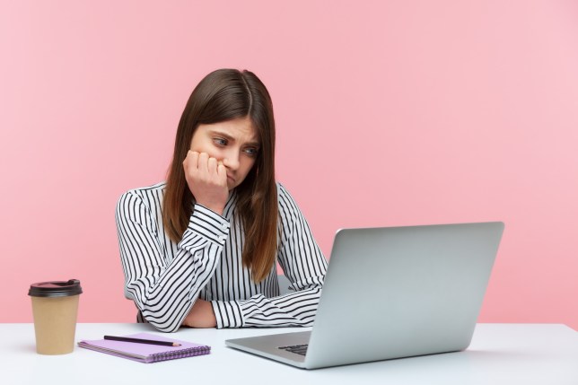 Woman looking anxiously at screen.