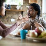 Angry black man arguing with his girlfriend during breakfast in the morning.