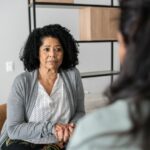 Serious mother listening to daughter at home or doing a psychology consultation