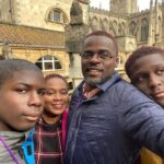 Anthony and Abi with their sons in a selfie in front of a cathedral