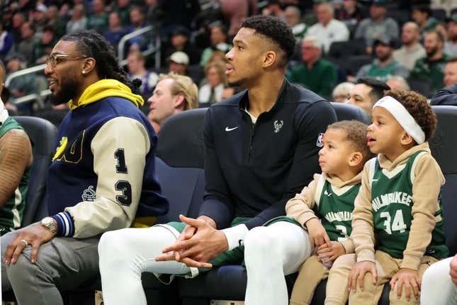 MILWAUKEE, WISCONSIN - DECEMBER 16: Giannis Antetokounmpo #34 of the Milwaukee Bucks sits on the bench with his children, Liam and Maverick, during a game against the Detroit Pistons at Fiserv Forum on December 16, 2023 in Milwaukee, Wisconsin. NOTE TO USER: User expressly acknowledges and agrees that, by downloading and or using this photograph, User is consenting to the terms and conditions of the Getty Images License Agreement. (Photo by Stacy Revere/Getty Images)