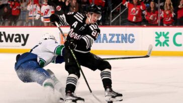 NEWARK, NEW JERSEY - FEBRUARY 06:  Jack Hughes #86 of the New Jersey Devils takes a shot as Quinn Hughes #43 of the Vancouver Canucks defends in the overtime at Prudential Center on February 06, 2023 in Newark, New Jersey. The New Jersey Devils defeated the Vancouver Canucks 5-4 in overtime. (Photo by Elsa/Getty Images)