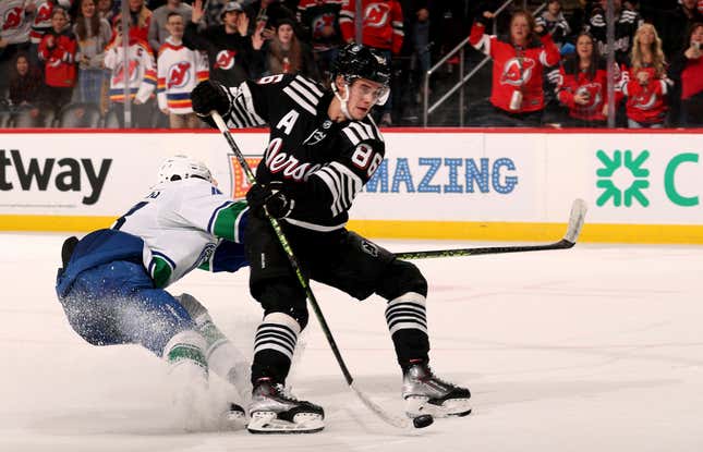 NEWARK, NEW JERSEY - FEBRUARY 06:  Jack Hughes #86 of the New Jersey Devils takes a shot as Quinn Hughes #43 of the Vancouver Canucks defends in the overtime at Prudential Center on February 06, 2023 in Newark, New Jersey. The New Jersey Devils defeated the Vancouver Canucks 5-4 in overtime. (Photo by Elsa/Getty Images)