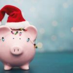 Pink Piggy Bank Wrapped in Holiday Lights and Wearing Santa Hat for Christmas