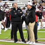 Jimbo Fisher (r.) chatting with Zach Arnett, possibly about how Fisher is going to spend his millions in severance.