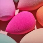 A set of makeup sponges on a pink background close-up.