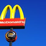 London, United Kingdom - June 2, 2011 : McDonald's yellow and red logo advertising sign placed on a pole with a clear blue sky with copy space