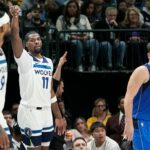 Minnesota Timberwolves center Naz Reid (11) reacts after hitting a 3-point basket as Dallas Mavericks guard Luka Doncic (77) looks on during the first half of an NBA basketball game in Dallas, Thursday, Dec. 14, 2023. (