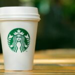 Tall Starbucks to go cup on wooden table