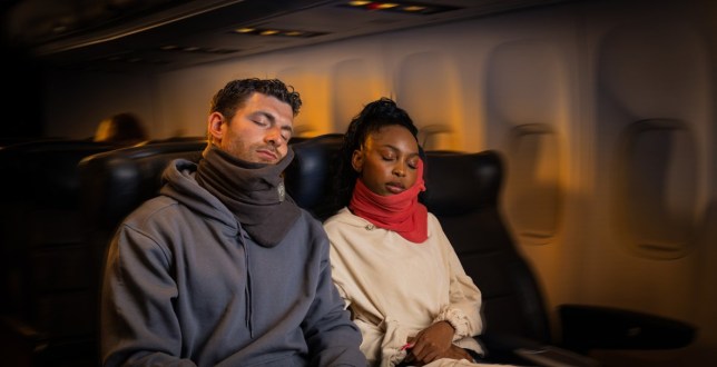 Two passengers sleeping on a flight during the night time - wearing trtl travel pillow