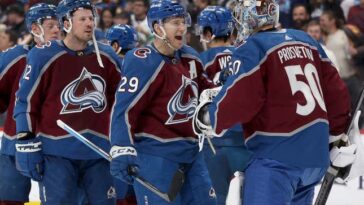 DENVER, COLORADO - DECEMBER 11: Nathan MacKinnon #29 of the Colorado Avalanche celebrates with goalie Ivan Prosvetov #50 after their win against the Calgary Flames at Ball Arena on December 11, 2023 in Denver, Colorado. (Photo by Matthew Stockman/Getty Images)