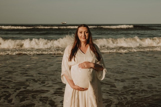 Ruth Barrett cradling pregnancy baby bump