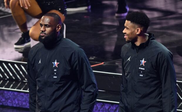 Pro-basketball players LeBron James (L) and Giannis Antetokounmpo (R) stand on stage during the mock draft ahead of the All-Star game between Team Giannis and Team LeBron at the Vivint arena in Salt Lake City, Utah, February 19, 2023.