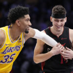 Los Angeles Lakers forward Christian Wood, left, appears to tickle Miami Heat guard Tyler Herro as they wait for a free throw during the second half of an NBA basketball game Wednesday, Jan. 3, 2024, in Los Angeles.
