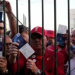 Liverpool fans show tickets and wait in front of the Stade de France prior the Champions League final soccer match between Liverpool and Real Madrid, in Saint Denis near Paris, Saturday, May 28, 2022. Police have deployed tear gas on supporters waiting in long lines to get into the Stade de France for the Champions League final between Liverpool and Real Madrid that was delayed by 37 minutes while security struggled to cope with the vast crowd and fans climbing over fences.