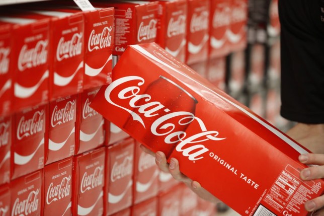 Multipacks of Coca Cola cans in a supermarket.