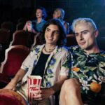 Gay couple on date at movie theatre