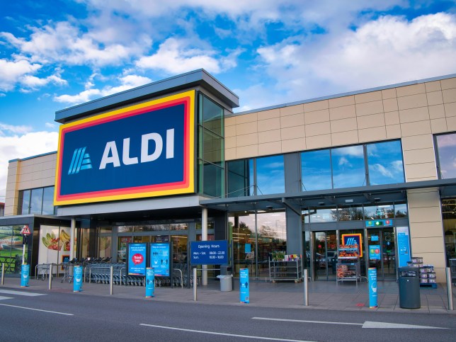 The frontage and brand logo of a branch of German discount retailer Aldi, taken in a local retail park on Wirral, UK on a sunny afternoon