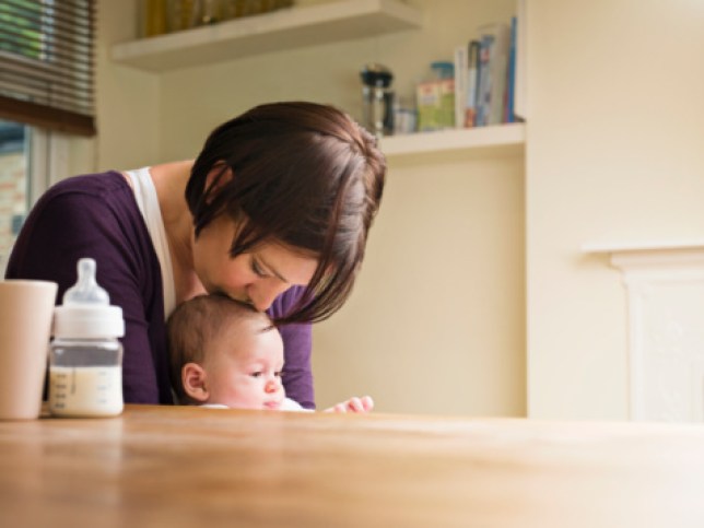 Mother kissing her baby in the kitchen