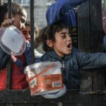 Children wait to receive food in the city of Rafah, southern Gaza.