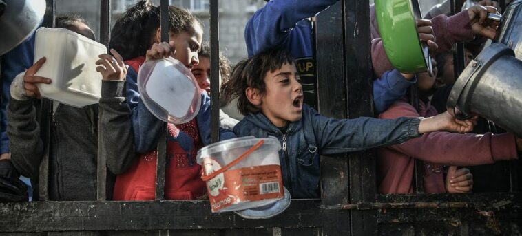 Children wait to receive food in the city of Rafah, southern Gaza.