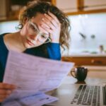 Woman going through bills, looking worried