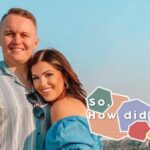 Alexis and Buddy standing in front of a town/mountain with blue sky behind them and the words 'So, How did it go?' in the corner against a patterned background