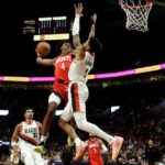 Houston Rockets guard Jalen Green (4) goes up for a dunk against Portland Trail Blazers guard Anfernee Simons, right, during the second half of an NBA basketball game in Portland, Ore., Friday, March 8, 2024. 
