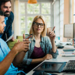 Diverse group of young colleagues making decision to buy a personal computer for business