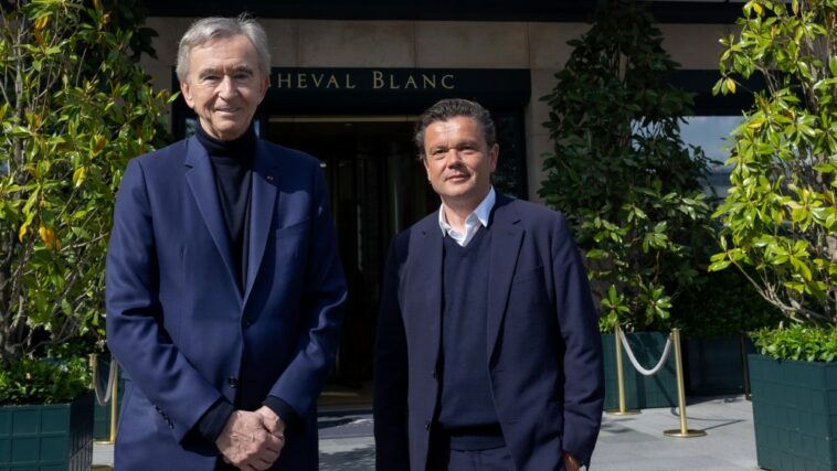 Bernard Arnault and Jean-Michel Othoniel pose in front of the Cheval Blanc Paris hotel.