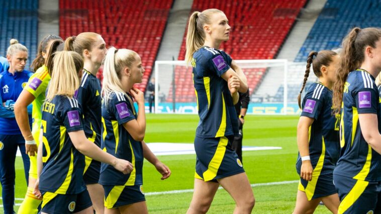 The Scotland squad head back into the dressing rooms as they waited for the protestor to be removed