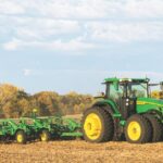 A John Deere Tractor driving in a field.