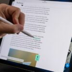 Demonstrating the Pencil hover feature on the 2022 iPad Pro by holding the Pencil over a link and seeing its destination in the lower-left corner.