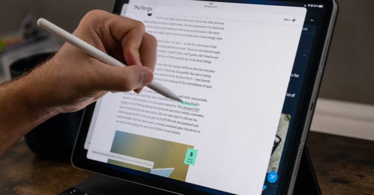 Demonstrating the Pencil hover feature on the 2022 iPad Pro by holding the Pencil over a link and seeing its destination in the lower-left corner.