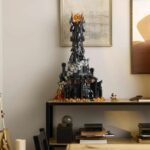 A wide-angle shot of Lego’s Barad-dûr set sitting on a table beside a lamp.